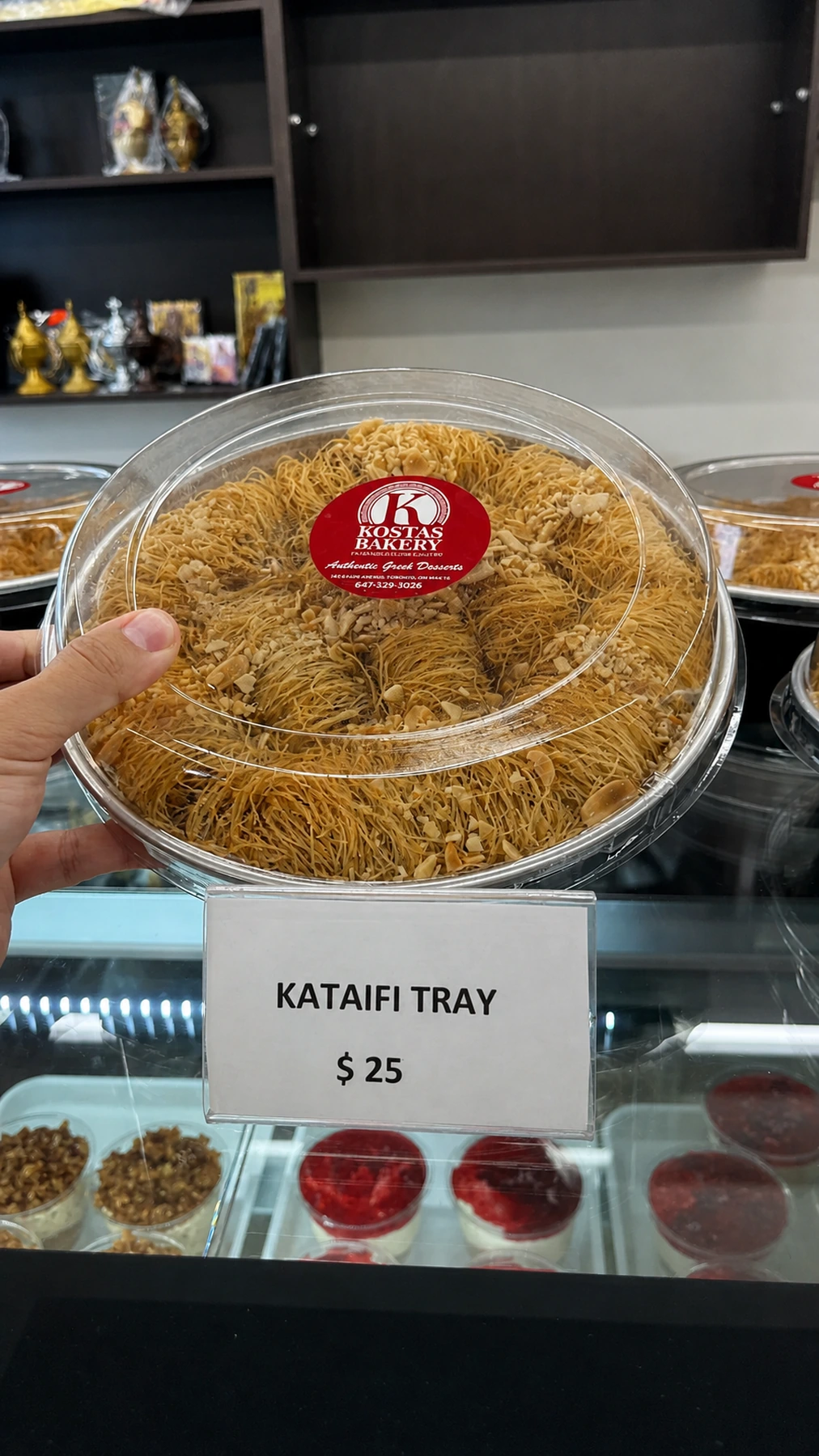 A large round kataifi tray with a Kostas bakery label