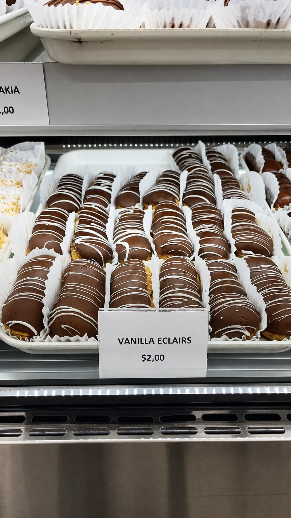 Vanilla eclairs decorated with chocolate drizzle