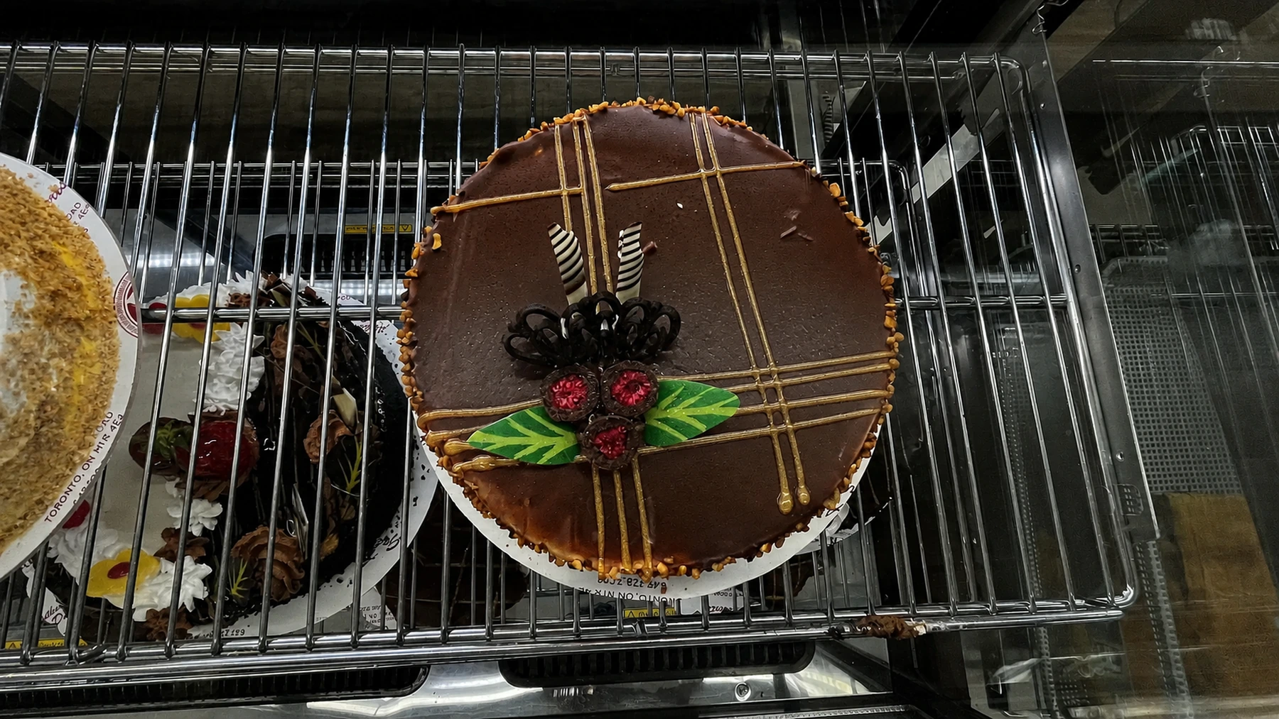 A decorated round chocolate cake in the bakery display