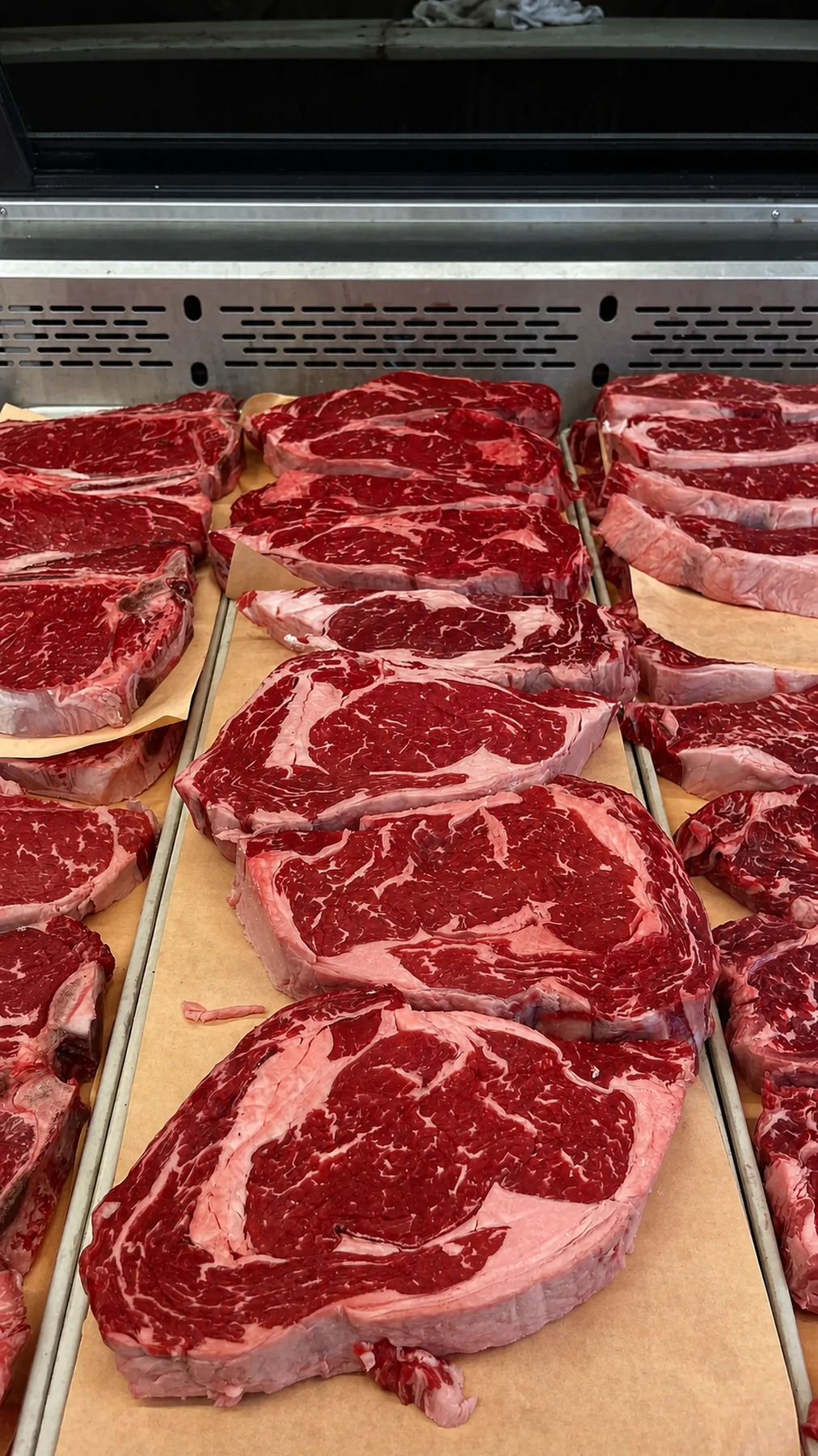 Fresh, richly marbled steaks arranged at the butcher counter