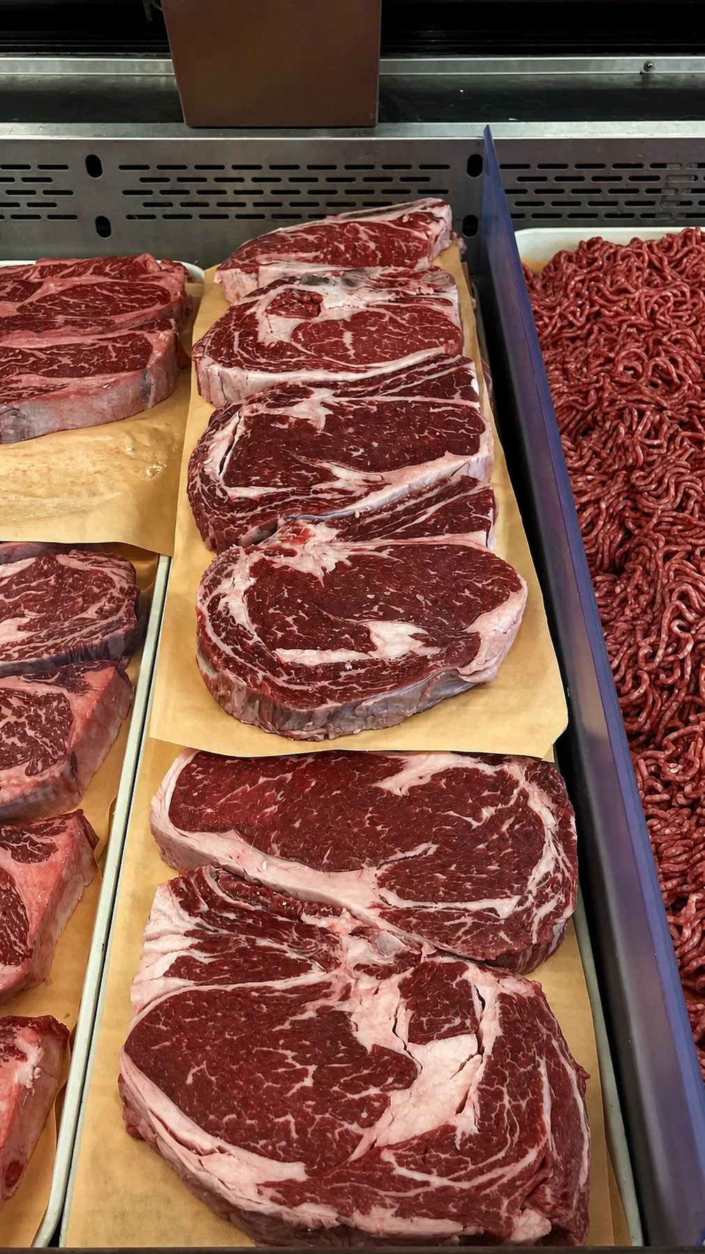 Ribeye steaks and ground meat displayed at the counter