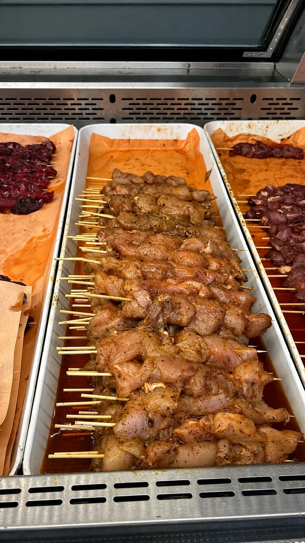 Seasoned chicken souvlaki skewers at the meat counter